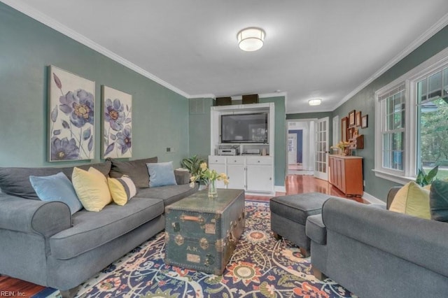 living area with ornamental molding, wood finished floors, and baseboards