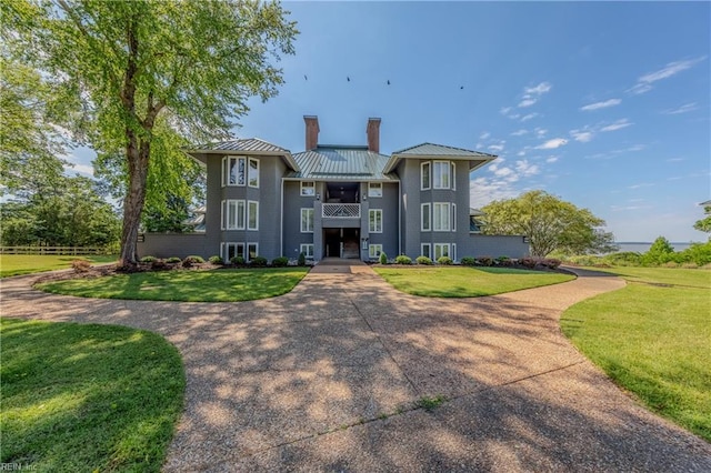 709 Graves Ordinary, Williamsburg, VA 23185 - view of front facade featuring a chimney, a balcony, a standing seam roof, and a front lawn