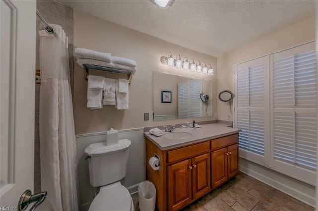 709 Graves Ordinary, Williamsburg, VA 23185 - bathroom with a textured ceiling, vanity, toilet, a shower with shower curtain, and a wainscoted wall