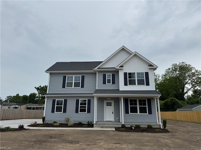 view of front of home with fence, a porch, board and batten siding, and a shingled roof