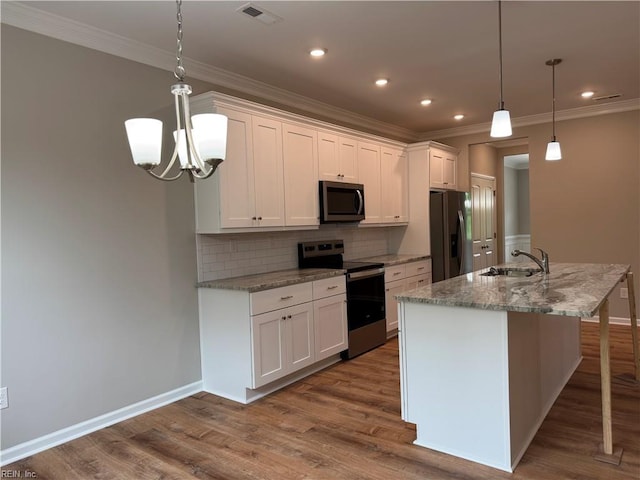 kitchen with stainless steel appliances, a sink, crown molding, tasteful backsplash, and white cabinets