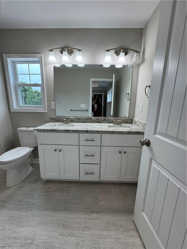 full bathroom with double vanity and toilet