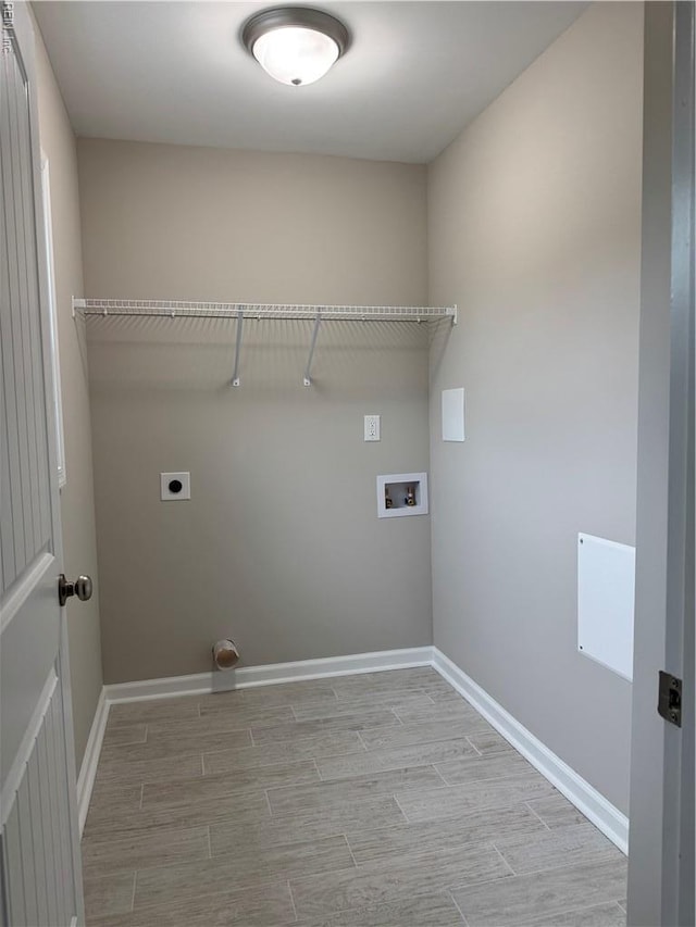 washroom with hookup for an electric dryer, wood tiled floors, washer hookup, and baseboards