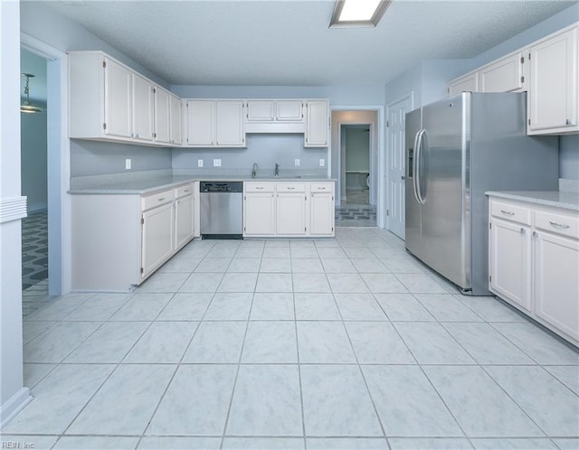 5191 Cypress Point Cir, Virginia Beach, VA 23455 - kitchen with stainless steel appliances, light countertops, white cabinetry, a sink, and light tile patterned flooring
