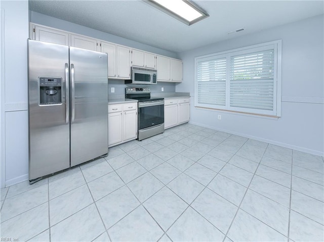 5191 Cypress Point Cir, Virginia Beach, VA 23455 - kitchen with stainless steel appliances, light countertops, white cabinetry, and baseboards