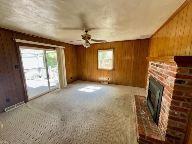 436 Clemson Ave, Chesapeake, VA 23324 - unfurnished living room featuring healthy amount of natural light, a fireplace, wood walls, a ceiling fan, and carpet floors