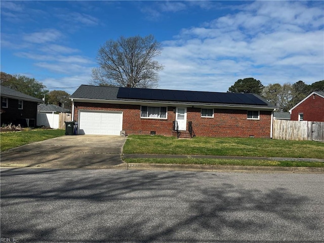 ranch-style house with an attached garage, entry steps, driveway, brick siding, and solar panels