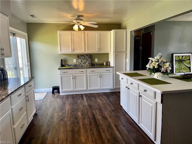 kitchen with white cabinets, a ceiling fan, dark wood-style flooring, and baseboards
