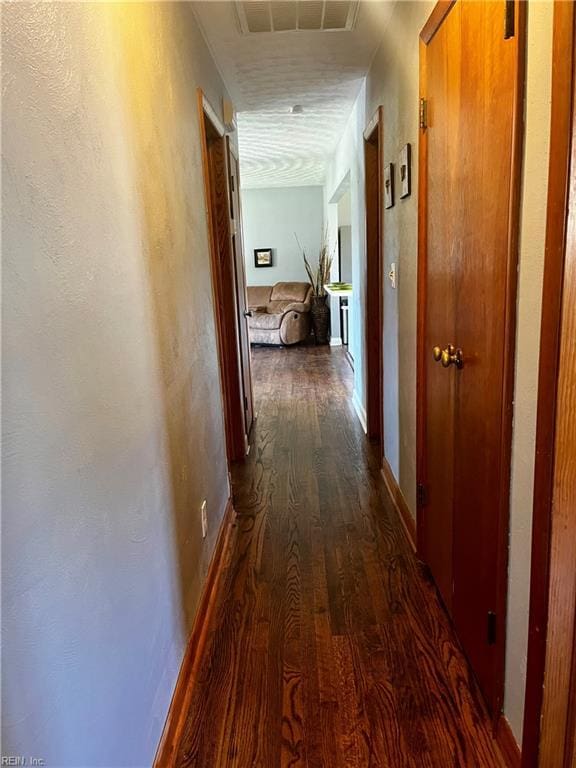 hall with dark wood-style floors and baseboards