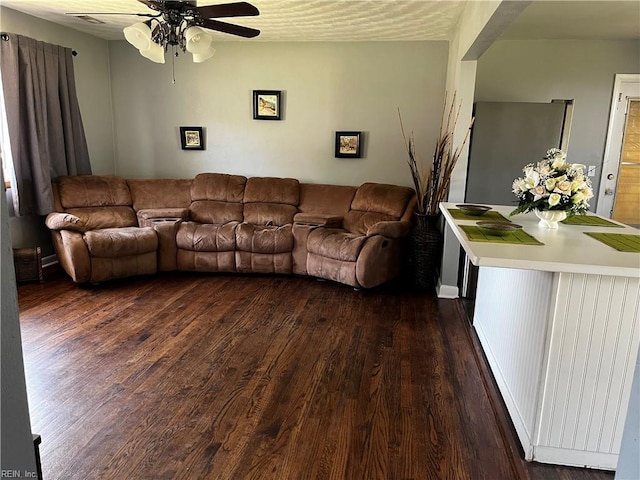 living area with dark wood-style floors and ceiling fan