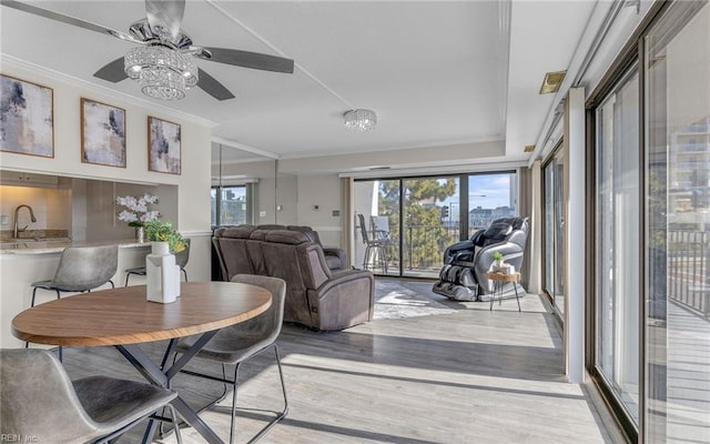 dining area featuring wood finished floors, ornamental molding, ceiling fan, and plenty of natural light