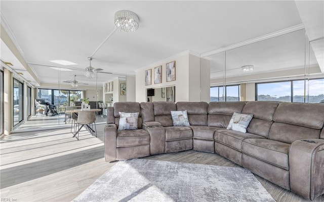 living room with wood finished floors, ornamental molding, and ceiling fan