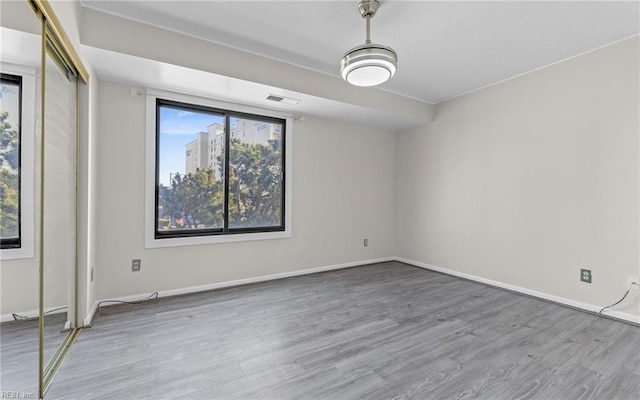 empty room with wood finished floors and baseboards