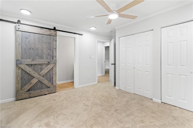1512 Shell Rd, Chesapeake, VA 23323 - unfurnished bedroom featuring ornamental molding, a barn door, carpet flooring, two closets, and baseboards