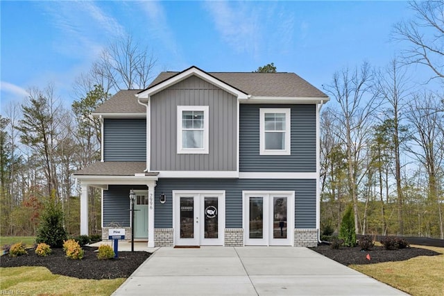 300 Mizzen Way, Elizabeth City, NC 27909 - view of front of property featuring french doors, board and batten siding, concrete driveway, and stone siding