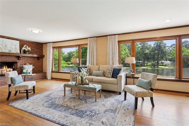 611 Windemere Rd, Newport News, VA 23602 - living room featuring light wood finished floors, baseboards, a brick fireplace, and crown molding