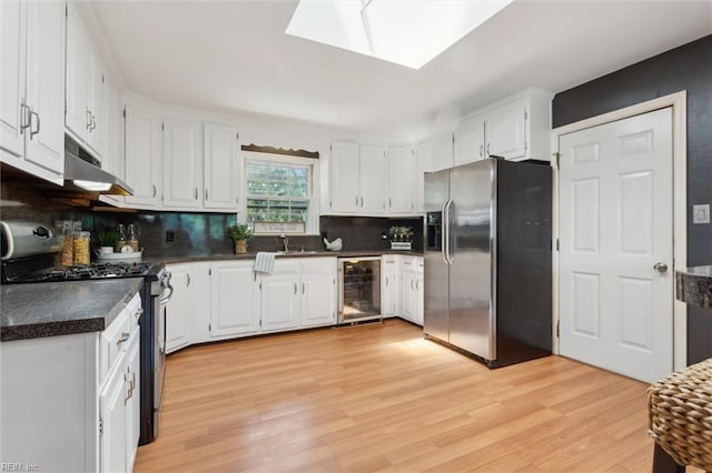 611 Windemere Rd, Newport News, VA 23602 - kitchen featuring stainless steel appliances, wine cooler, under cabinet range hood, dark countertops, and decorative backsplash