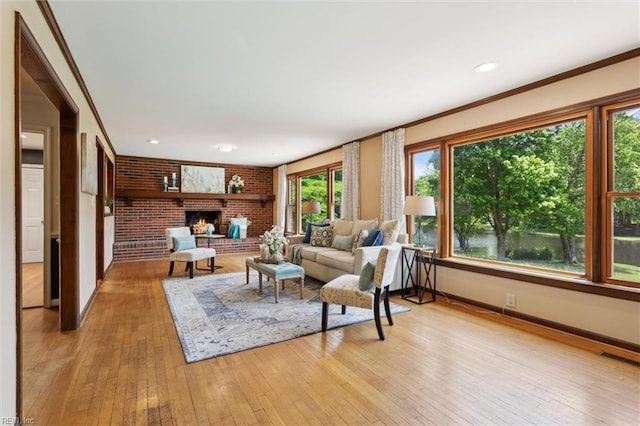 611 Windemere Rd, Newport News, VA 23602 - living area with baseboards, light wood-style floors, a brick fireplace, ornamental molding, and brick wall