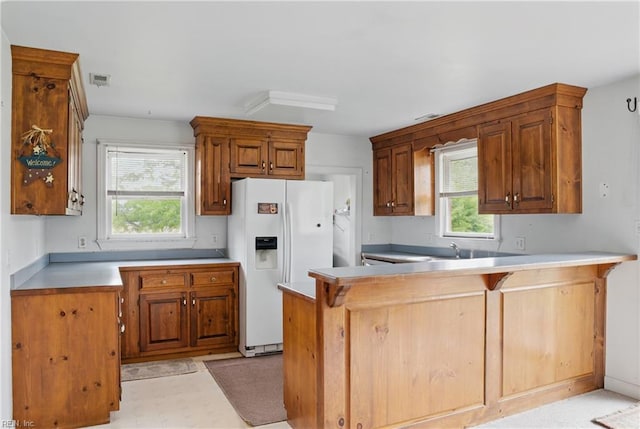 512 S End Rd, Knotts Island, NC 27950 - kitchen featuring white refrigerator with ice dispenser, a peninsula, plenty of natural light, and light countertops
