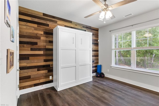 219 Dunway Ln, Chesapeake, VA 23323 - unfurnished bedroom with wooden walls, dark wood-style floors, baseboards, and ceiling fan