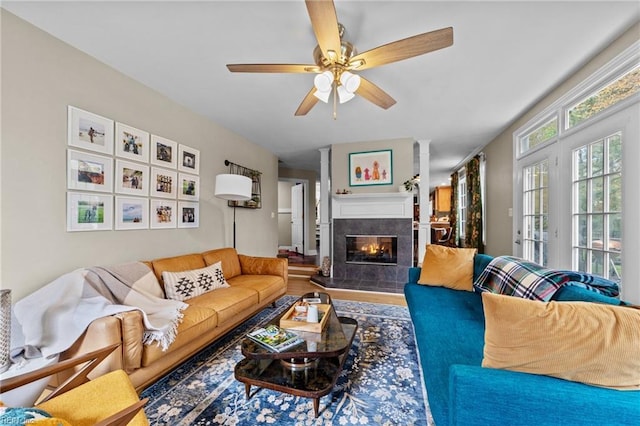 living area with ceiling fan, a fireplace, and wood finished floors