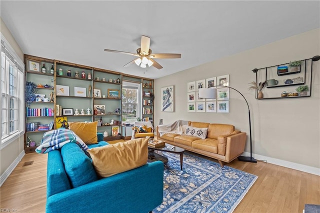 living area featuring baseboards, wood finished floors, and ceiling fan