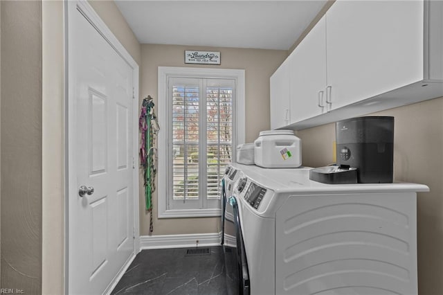 laundry room featuring separate washer and dryer, baseboards, cabinet space, and dark tile patterned flooring