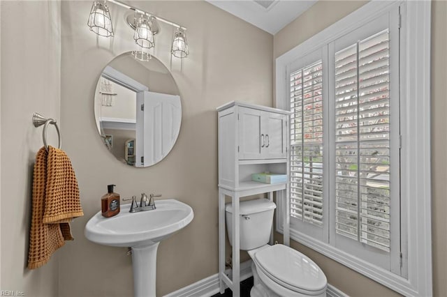 half bath featuring toilet and baseboards