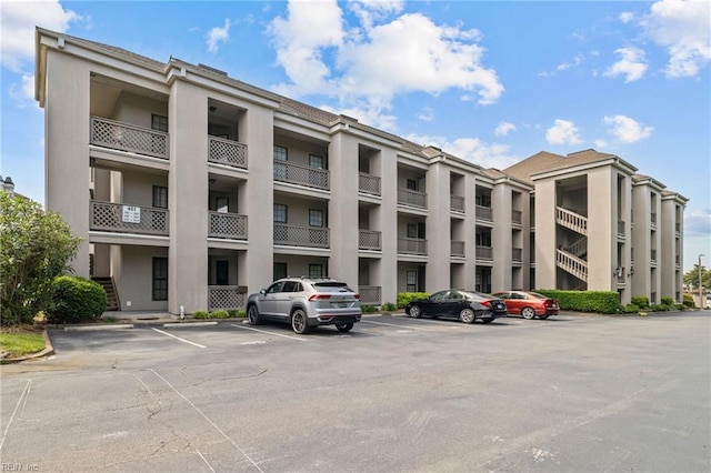view of apartment building / complex with uncovered parking