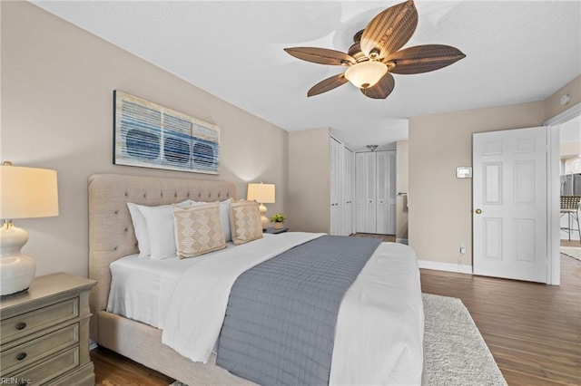 bedroom with wood finished floors, a ceiling fan, and baseboards