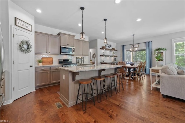 7935 Patriots Landing Pl, Quinton, VA 23141 - kitchen featuring appliances with stainless steel finishes, a sink, dark wood-type flooring, a breakfast bar, and decorative backsplash