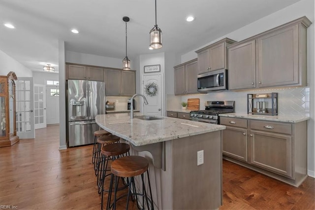 7935 Patriots Landing Pl, Quinton, VA 23141 - kitchen featuring appliances with stainless steel finishes, a sink, backsplash, a kitchen breakfast bar, and recessed lighting