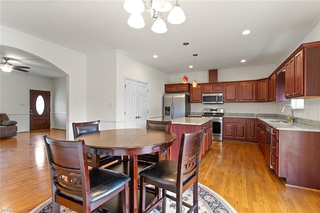 dining room featuring light wood-style flooring, crown molding, a chandelier, recessed lighting, and a ceiling fan