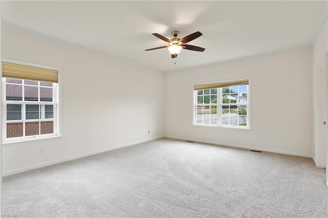 empty room featuring ornamental molding, ceiling fan, baseboards, and carpet flooring