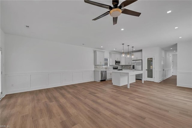 20 Kimberly Ave, Hampton, VA 23663 - unfurnished living room featuring light wood-style floors, a decorative wall, wainscoting, a ceiling fan, and recessed lighting