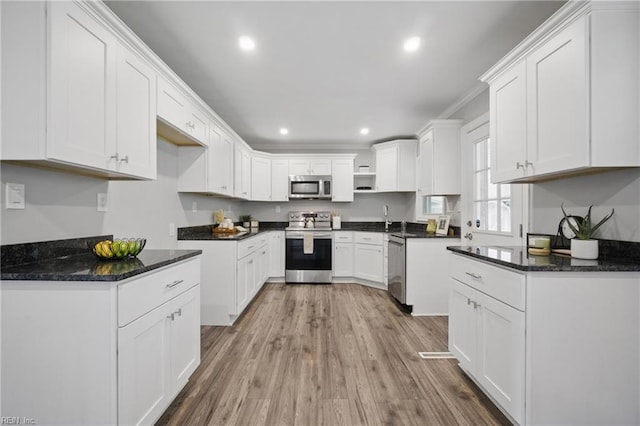 kitchen with stainless steel appliances, recessed lighting, wood finished floors, white cabinetry, and open shelves
