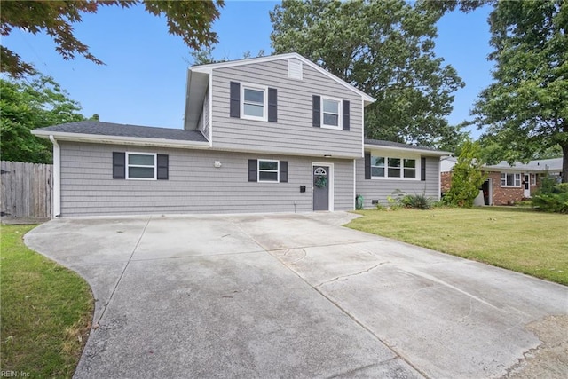 split level home with driveway and roof with shingles