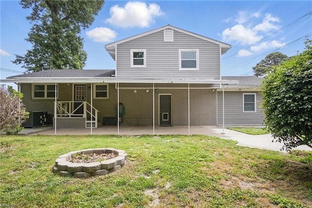 back of property with a patio area, a lawn, an outdoor fire pit, and cooling unit