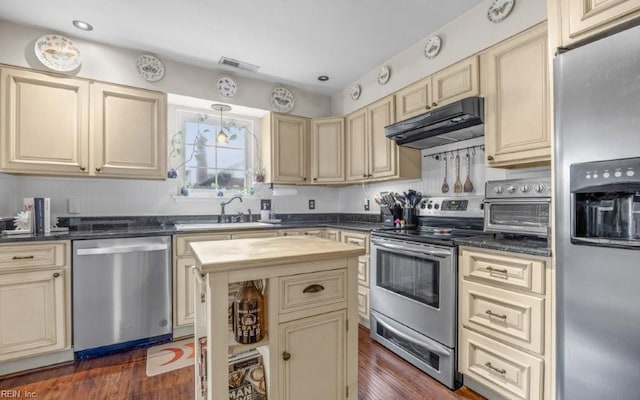 5009 Meadow Pines Pl, Virginia Beach, VA 23464 - kitchen with appliances with stainless steel finishes, cream cabinets, under cabinet range hood, a sink, and dark wood finished floors