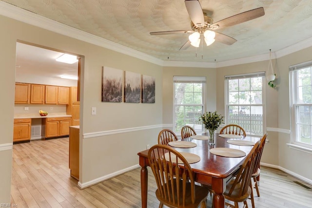 dining room with light wood-style flooring, baseboards, a ceiling fan, and ornamental molding