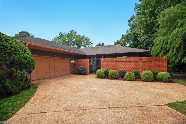 38 Yeardleys Grant, Williamsburg, VA 23185 - view of front of house featuring a garage, fence, driveway, and roof with shingles