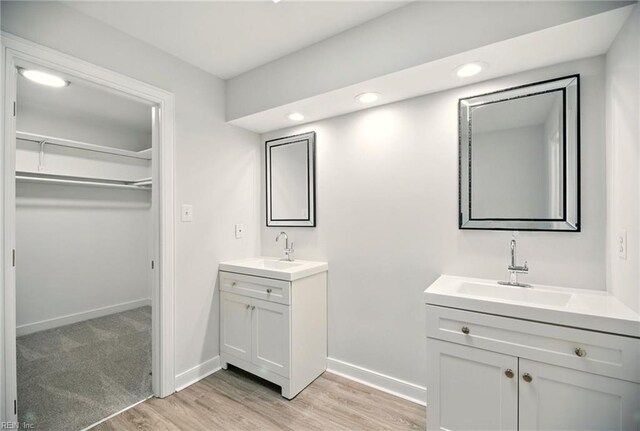 38 Yeardleys Grant, Williamsburg, VA 23185 - bathroom featuring wood finished floors, two vanities, a spacious closet, recessed lighting, and baseboards