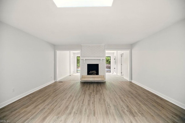 38 Yeardleys Grant, Williamsburg, VA 23185 - unfurnished living room featuring wood finished floors, baseboards, and a fireplace