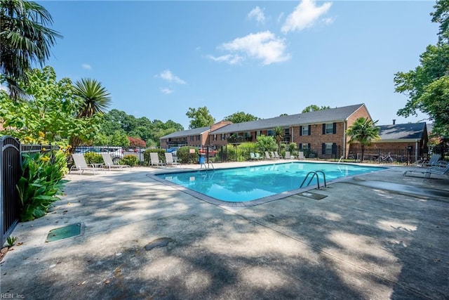community pool featuring fence and a patio