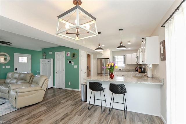 823 Jessie Cir, Newport News, VA 23608 - kitchen featuring freestanding refrigerator, open floor plan, a peninsula, white cabinetry, and light stone counters