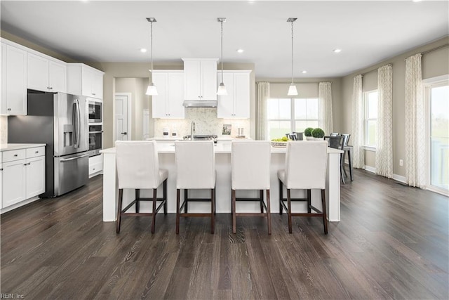 1115 Egret Ln, Suffolk, VA 23434 - kitchen featuring appliances with stainless steel finishes, a breakfast bar area, tasteful backsplash, an island with sink, and recessed lighting