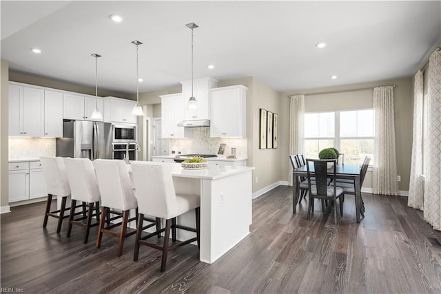 1115 Egret Ln, Suffolk, VA 23434 - kitchen featuring stainless steel appliances, decorative backsplash, an island with sink, dark wood-type flooring, and recessed lighting