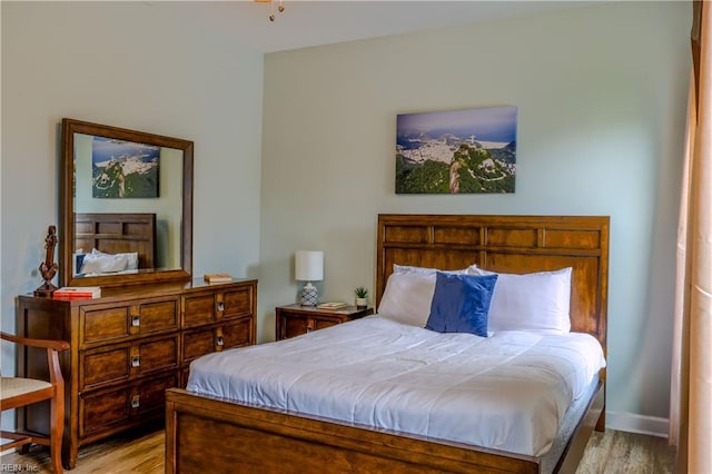 bedroom with light wood-type flooring and baseboards