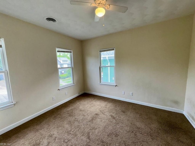 unfurnished room with dark carpet, baseboards, and a ceiling fan