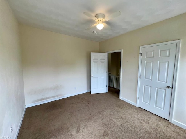 unfurnished bedroom featuring carpet flooring, baseboards, and a ceiling fan